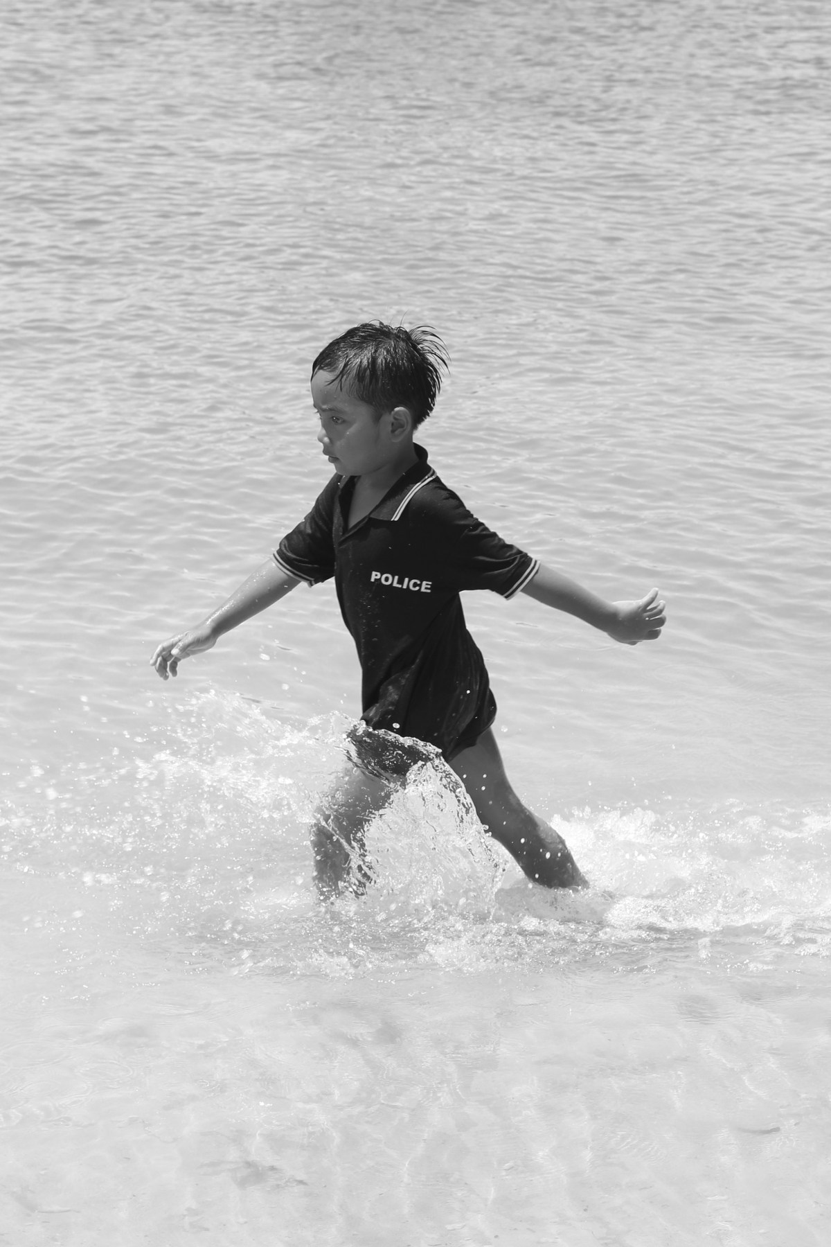 Child policeman walking into the water